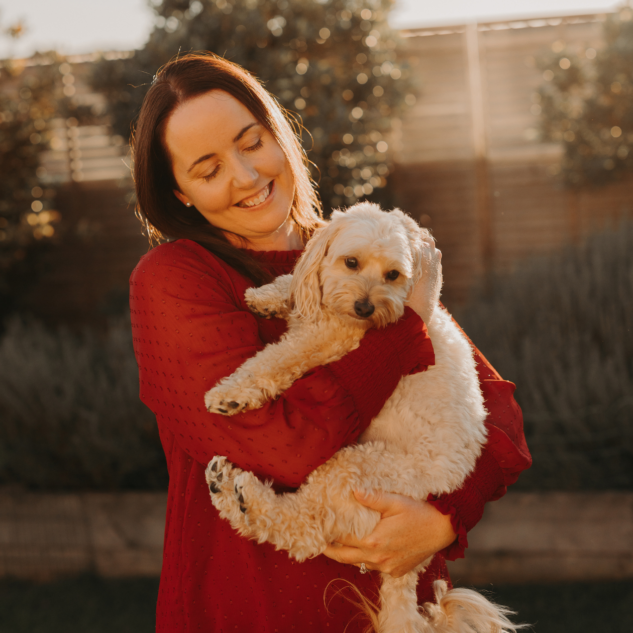 SEO copywriter Jane Havercroft holds her moodle dog Charlie in her backyard